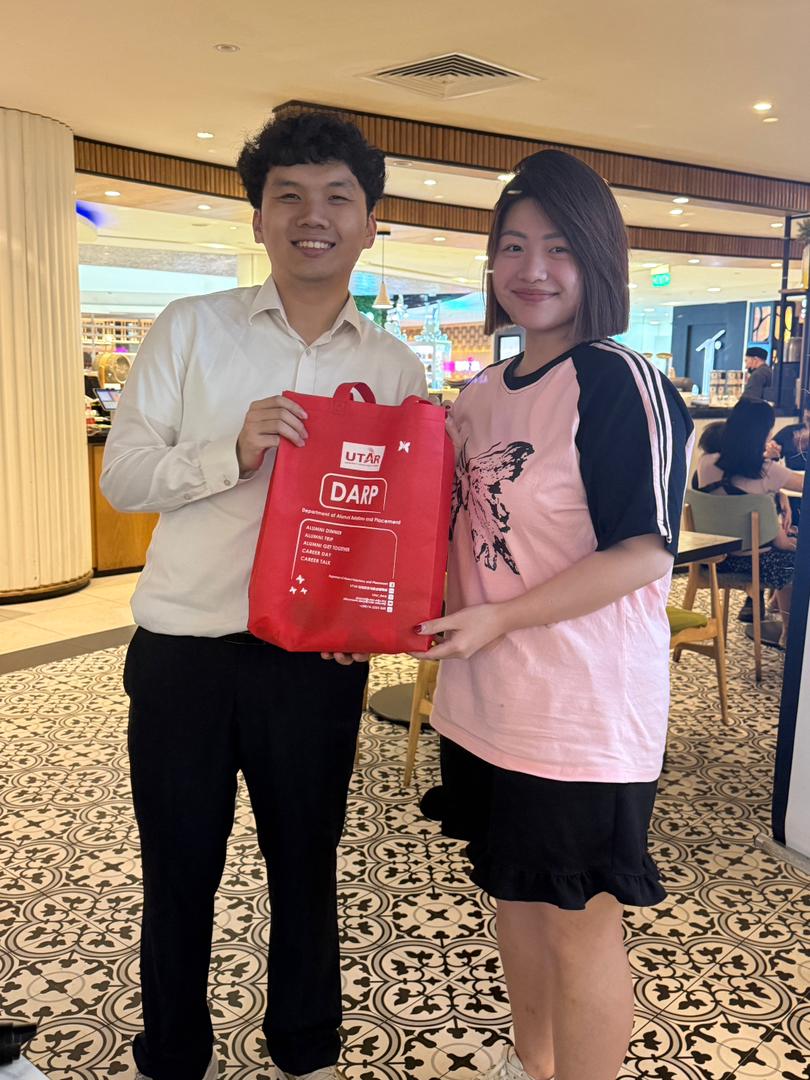 Mr Sia (left) presenting gifts to the lucky draw winners
