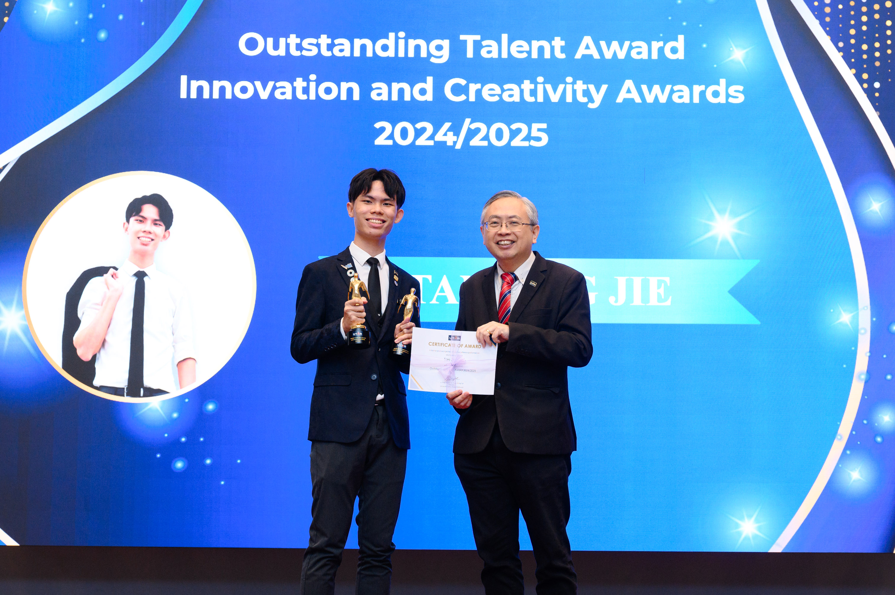 Mr Tan (left) displaying his awards