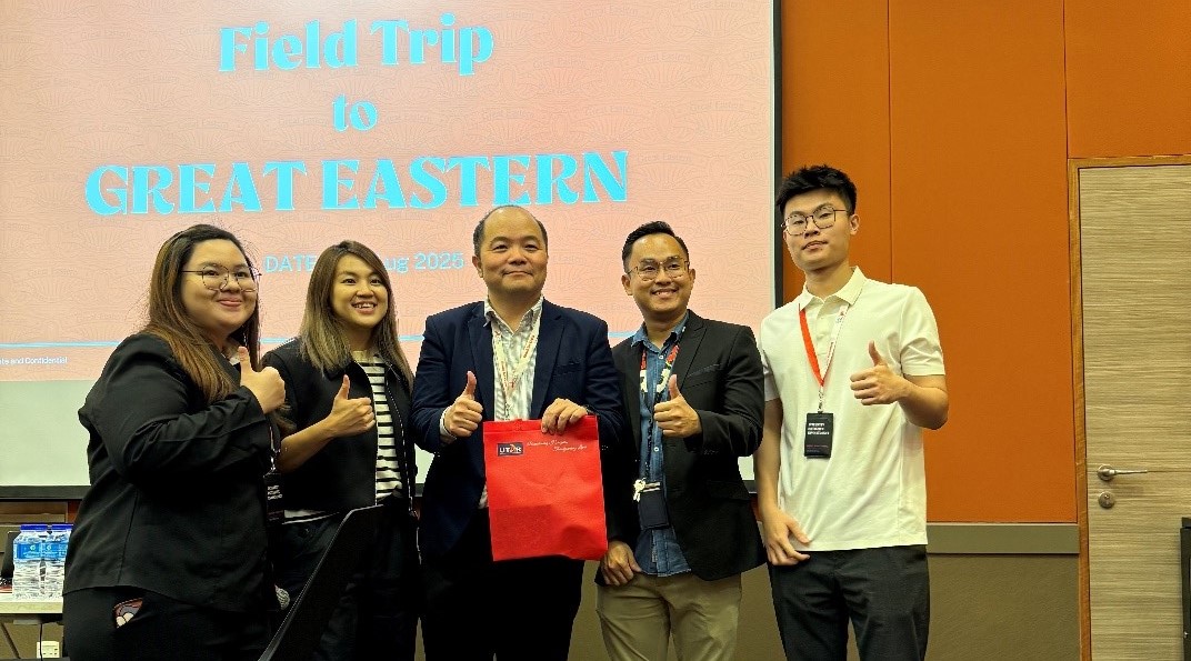 Mr Low (second from right) presenting a token of appreciation to Mr Scott (middle)