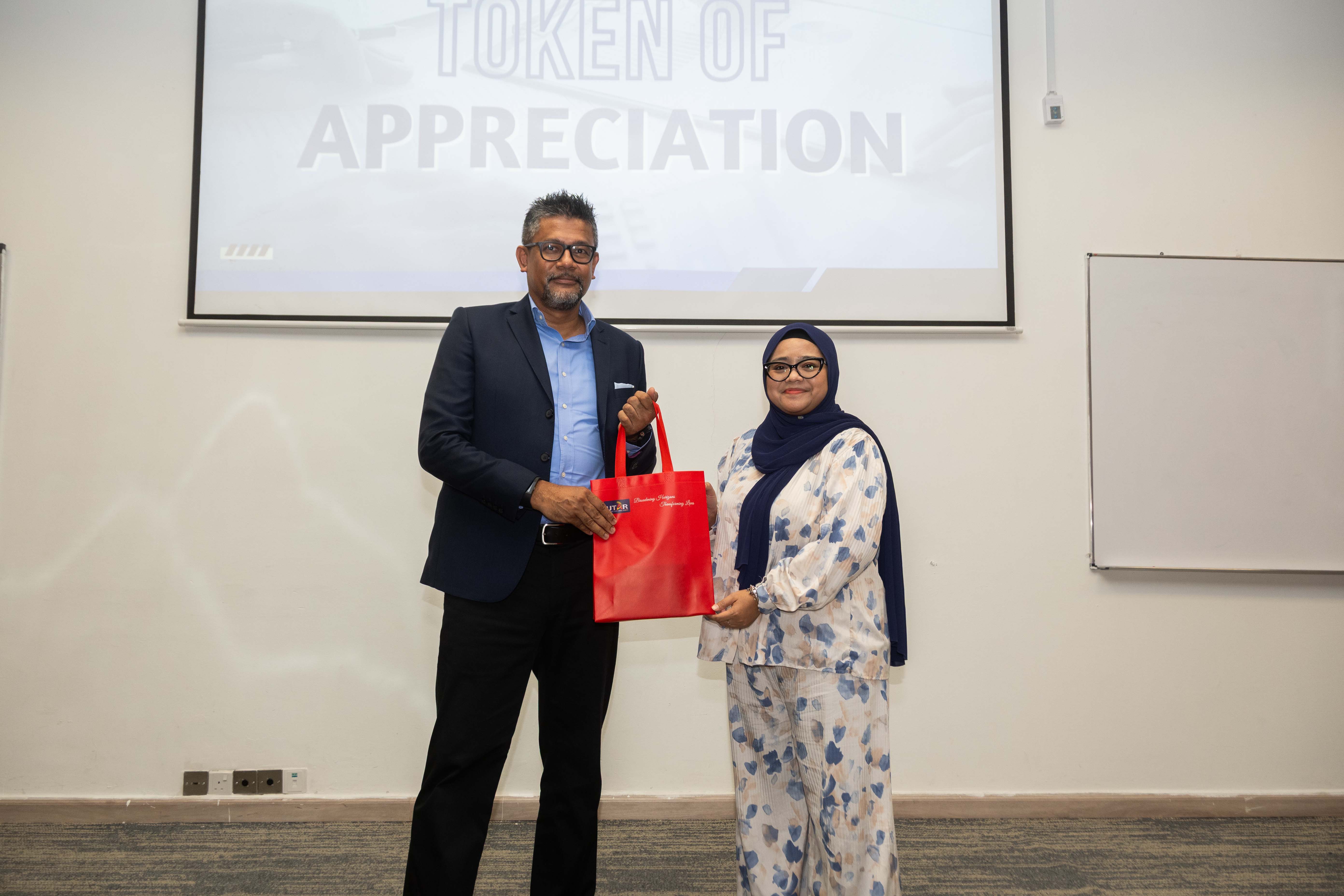 Ms Zufara Arneeda presenting a token of appreciation to Mr Ahmad Zubir