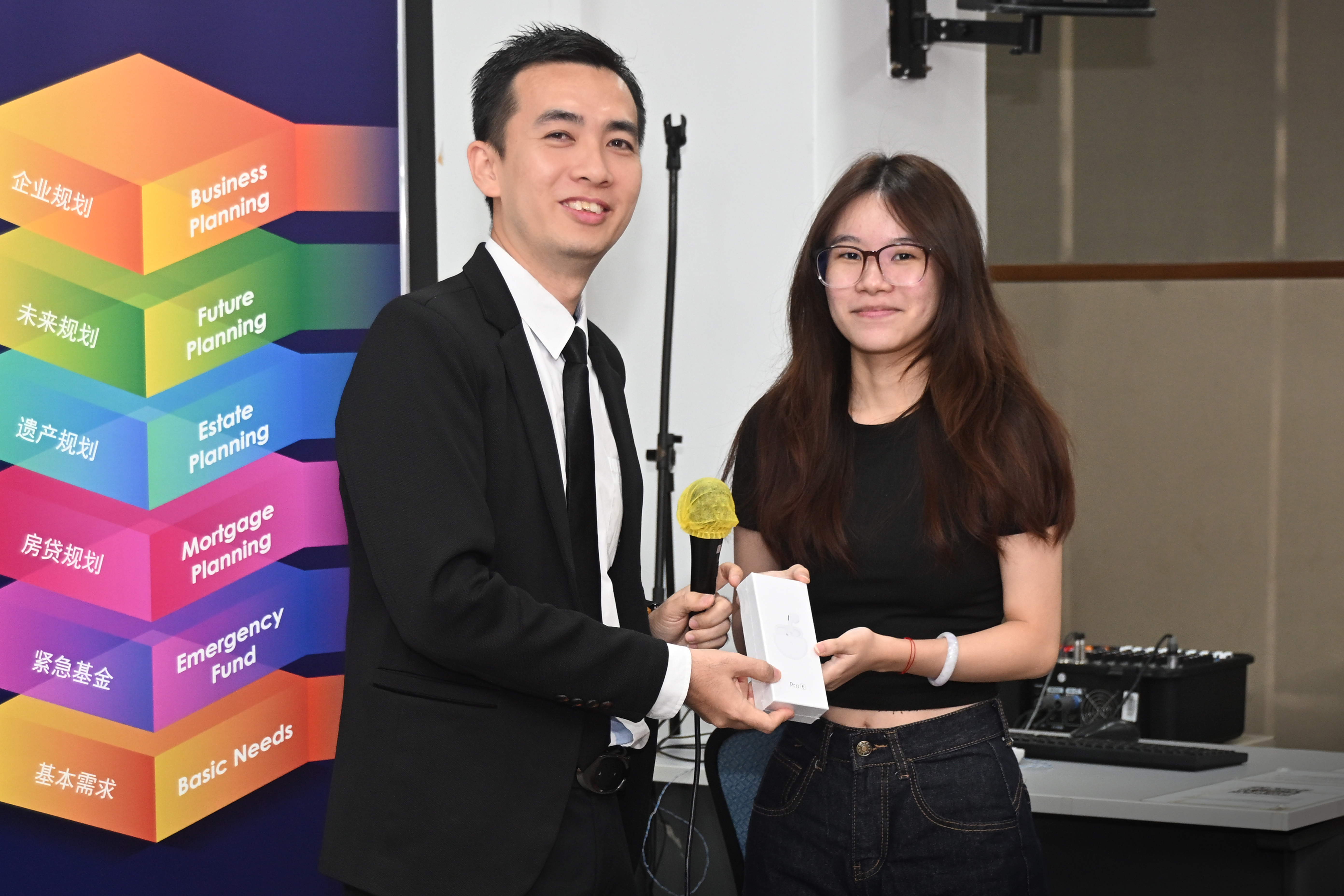 Mr Wong presenting the prizes to the top achievers in the quiz he prepared